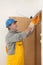 Worker installing wooden door, using polyurethane foam