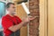 Worker installing wooden door, using polyurethane foam