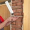 Worker installing wooden door, using polyurethane foam