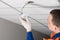 A worker installs lighting equipment into the false ceiling