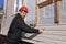 A worker installs panels beige siding on the facade