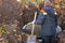 A worker installs a sewer in the ground, and a loader lowers a concrete ring into a dug hole to build a septic tank