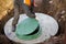 A worker installs a sewer manhole on a septic tank made of concrete rings. Construction of sewerage networks for country