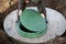 A worker installs a sewer manhole on a septic tank made of concrete rings. Construction of sewerage networks for country houses