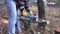 Worker in jeans and a plaid shirt with electric chain saw in his hands