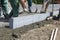 A worker knocks with a hammer aligns a concrete curb.