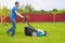 Worker with a lawn mower mows grass in the garden