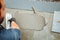 worker laying adhesive and placing ceramic tiles on waterproof floor