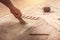 Worker laying parquet flooring, hands of the master close-up imposes rubber glue. Worker installing wooden laminate flooring