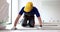 Worker laying vinyl or laminate flooring renovating home or office