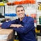 Worker Leaning On Tool Package In Hardware Shop