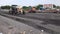 Worker Leveling Fresh Asphalt On A Road Construction Site