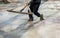 Worker leveling with wooden trowel the fresh poured concrete or cement at construction site