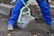 Worker lifts concrete curb with a manual lifting tool.