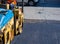 Worker on light vibration roller compactor at asphalt