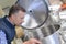 Worker looking inside metal vat