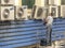 Worker maintains an air conditioner on the facade of a store in downtown Sao Paulo