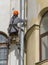 Worker makes cosmetic repairs of the facade of the house. Russia. Saint-Petersburg. Foundry Avenue house 55.