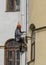 Worker makes cosmetic repairs of the facade of the house. Russia. Saint-Petersburg. Foundry Avenue house 55.