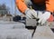 A worker makes a marking on a concrete block.