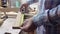 Worker makes measurements of a wooden board with tape measure. The carpenter measures the length of the board with a metal tape