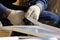 The worker makes the sladding of windows in the restored building in the city, cuts the metal sheet for the slope with scissors.