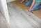 Worker making laminate flooring in apartment. Maintenance repair renovation. Wooden parquet planks indoors