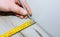 Worker making laminate flooring in apartment. Measure tape and pencil in hands. Maintenance repair renovation. Wooden parquet