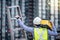 Worker man carrying aluminium ladder and tool box