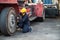 Worker man operate checking and fix the wheels forklift crane at container cargo harbor