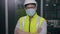 Worker man technician or engineering wearing protective mask and helmet standing with arms crossed