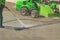 Worker man in uniform washes street or square. Municipal service of city cleaning process. Guy uses water spray equipment and