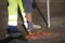 Worker marks a spot on asphalt with florescent spray paint