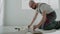 Worker measures parquet board makes mark sitting on floor