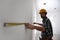 Worker measuring white wall, focus on hand
