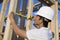 Worker Measuring Wooden Beams On Site