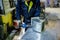 Worker in metalworking plant installing a rivets into part for construction ducts by using pneumatic riveter