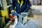 Worker in metalworking plant installing a rivets into part for construction ducts by using pneumatic riveter