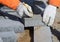 A worker in mittens makes markings on the paving slabs.