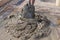 Worker mixing concrete and gravel  with spade on construction cite