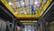 Worker monitors operation of equipment in factory. Stock footage. Bottom view of worker passing over working turbines