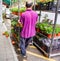 A worker moves a rack of indoor flowers