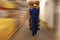 Worker moving wooden pallets with manual forklift in warehouse, back view