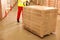 Worker moving wooden pallets wrapped in stretch indoors