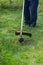 Worker mows grass and weeds with a lawn mower