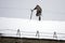 The worker of the municipal service clears the roof of the accumulated snow in the .