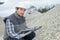 Worker next to pile stones