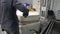 A worker opens the door of the tempering furnace. Quenching of steel billets. Metalworking shop.