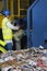 Worker Operating Conveyor Belt In Recycling Factory