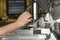 Worker operating metal press machine at workshop